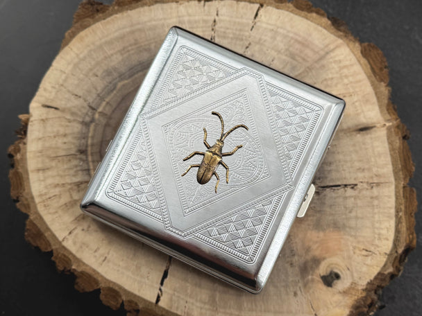 Silver entomology business card holder with a bronze longhorn beetle and geometric metal design
