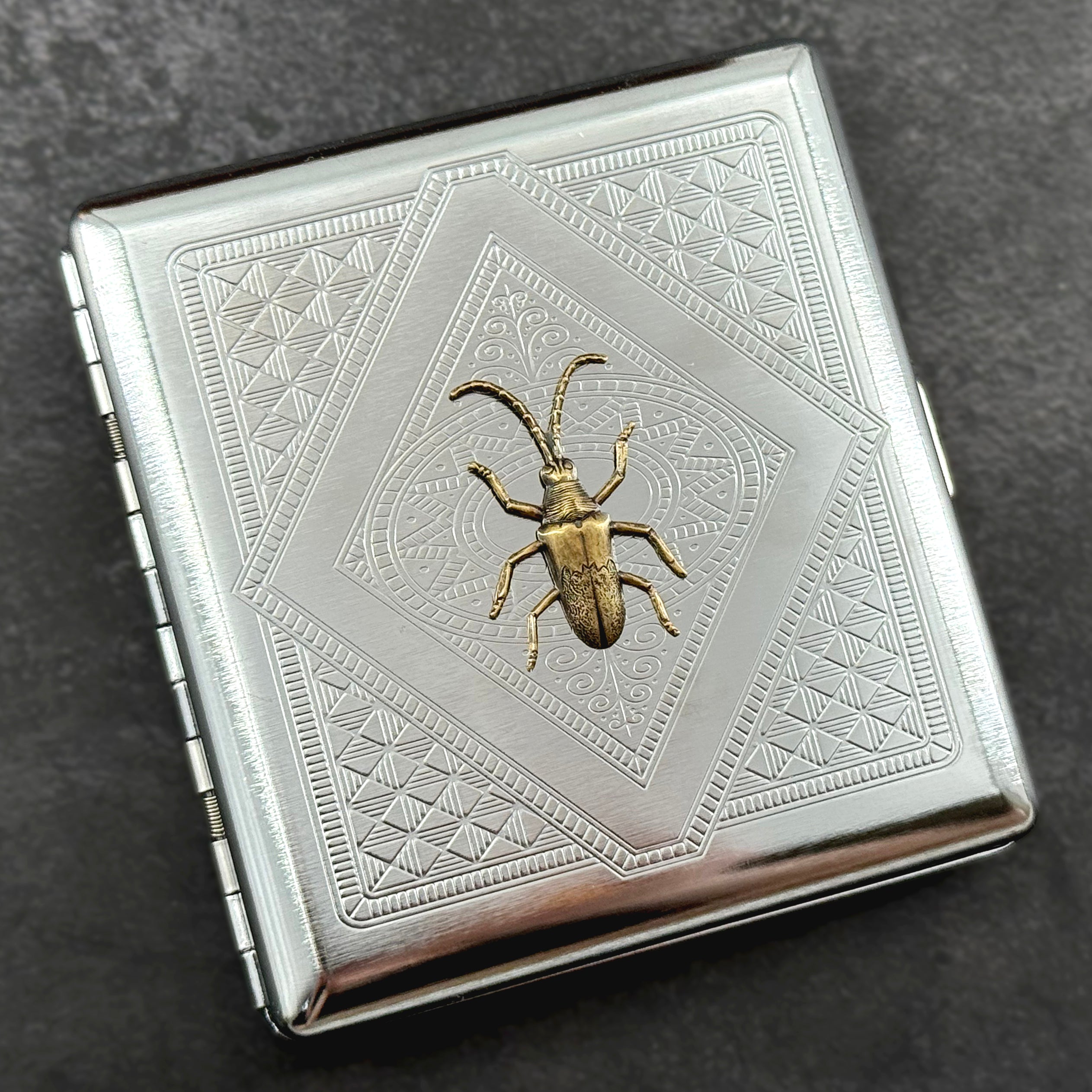 Victorian-inspired beetle pocket case featuring an ornate geometric stamped pattern