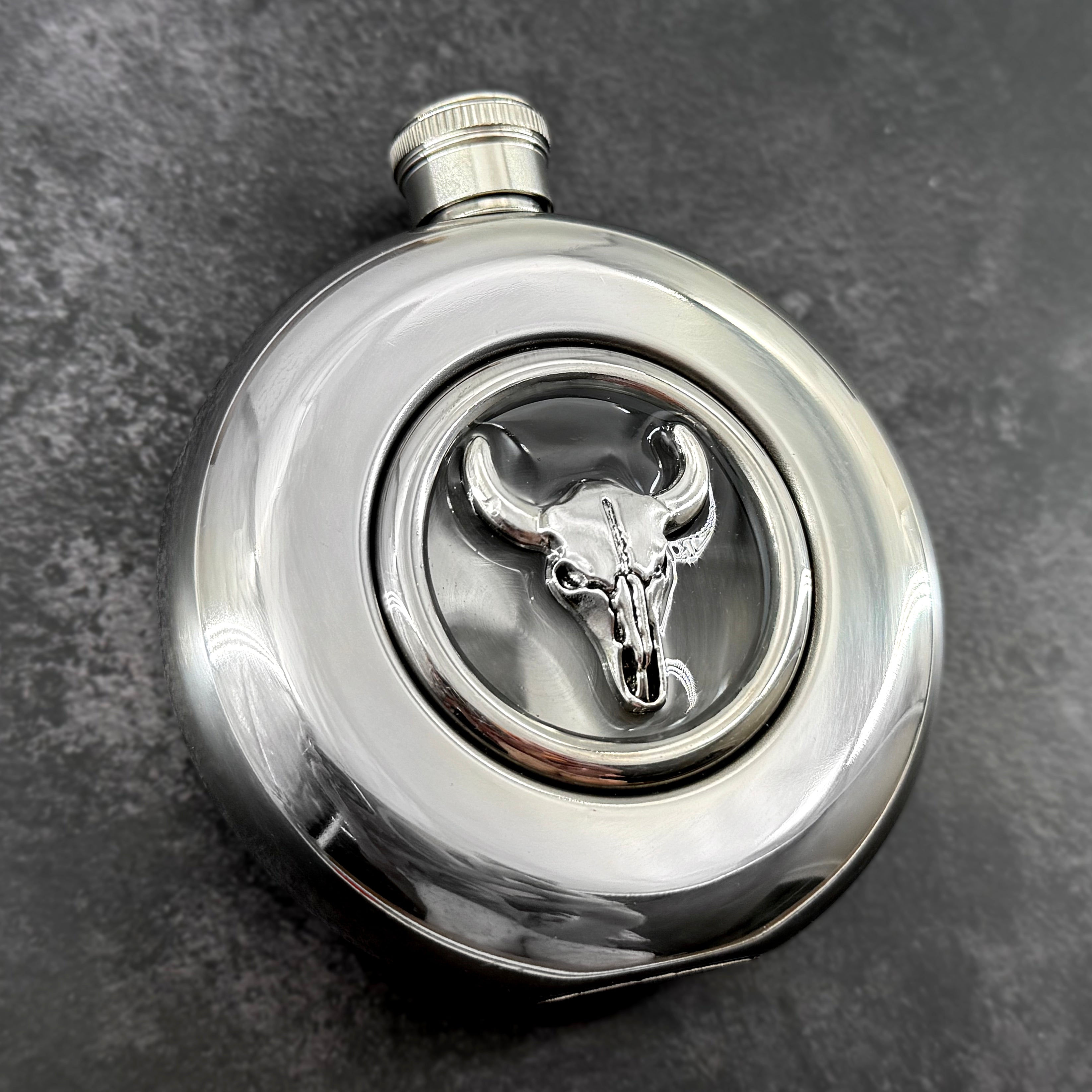 Mirror-finish 5 oz hip flask featuring a silver-toned bull skull centerpiece