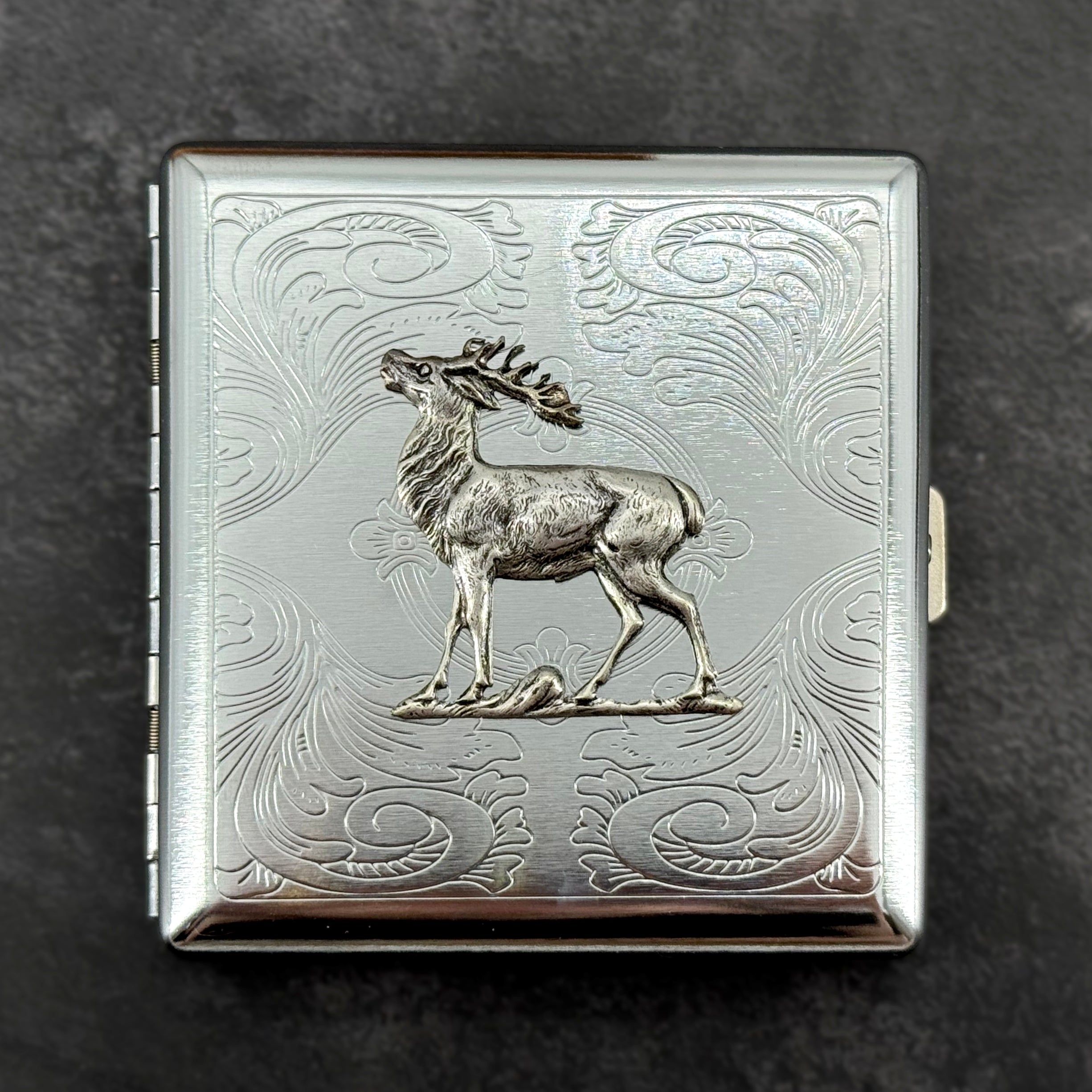 Close-up of raised elk embellishment on a handcrafted silver metal case