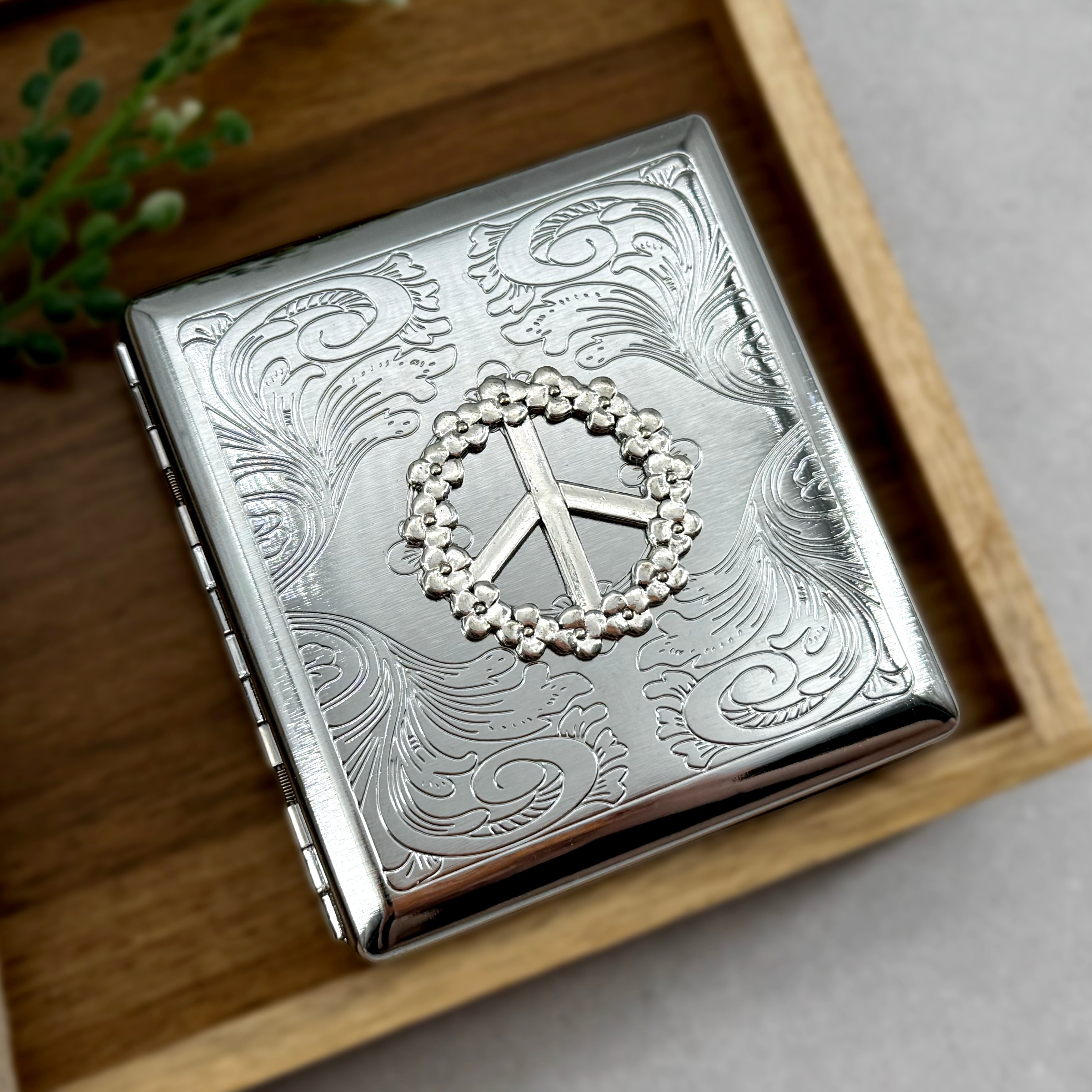 Handmade peace sign cigarette case with flower border and ornate scrollwork detailing