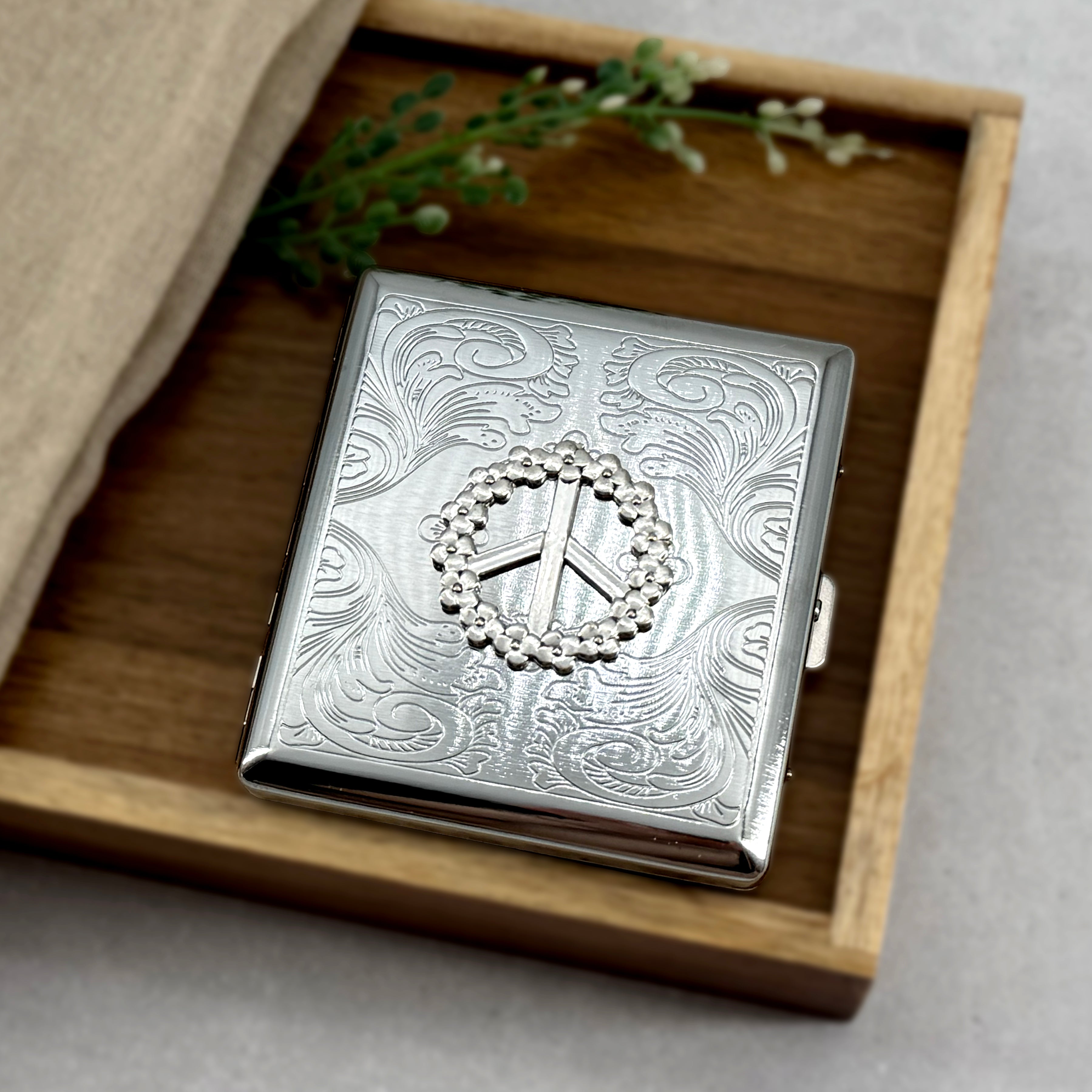 Floral peace symbol card holder with engraved metal finish and secure snap closure
