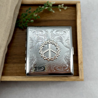Retro-inspired cigarette case featuring flower power peace sign design