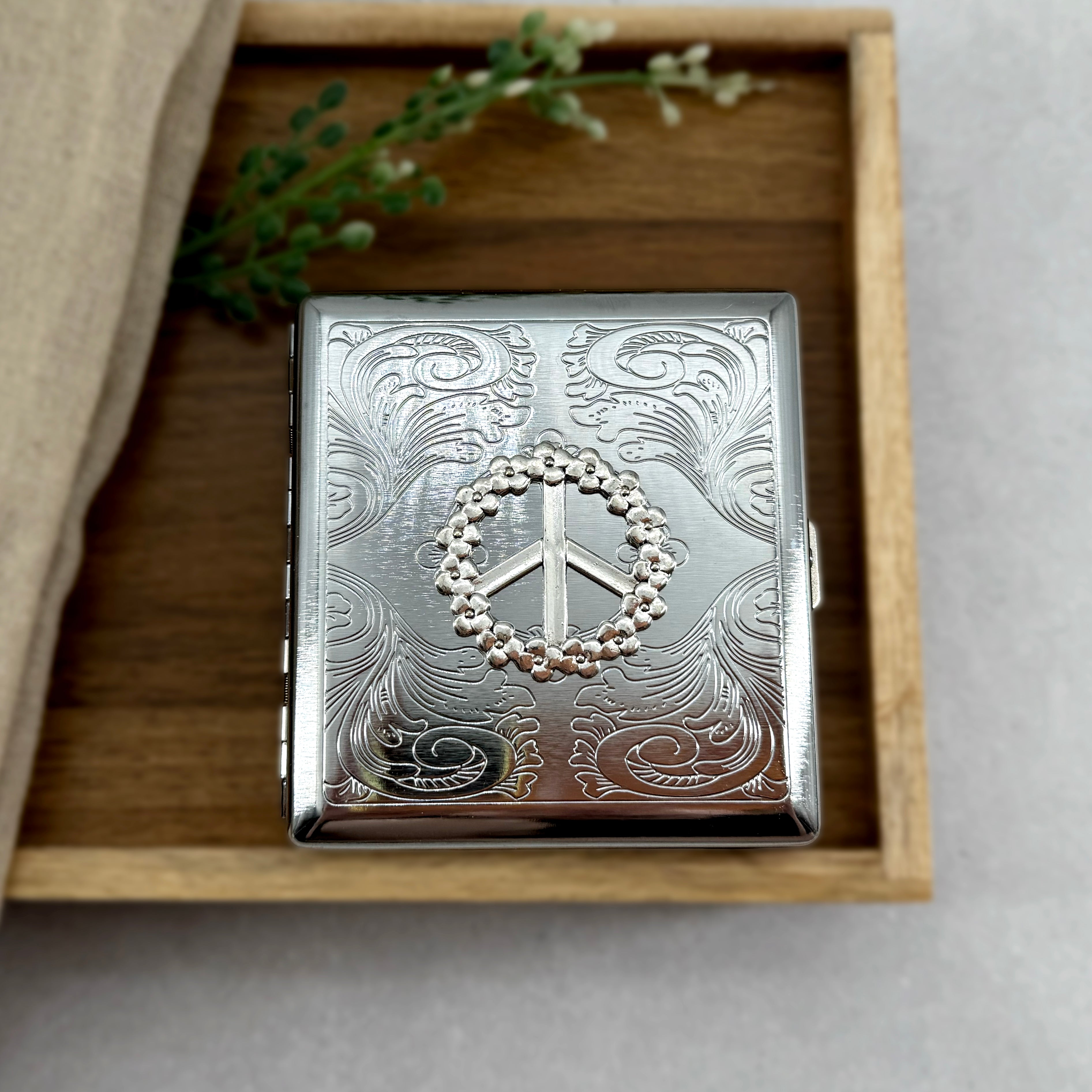 Retro-inspired cigarette case featuring flower power peace sign design
