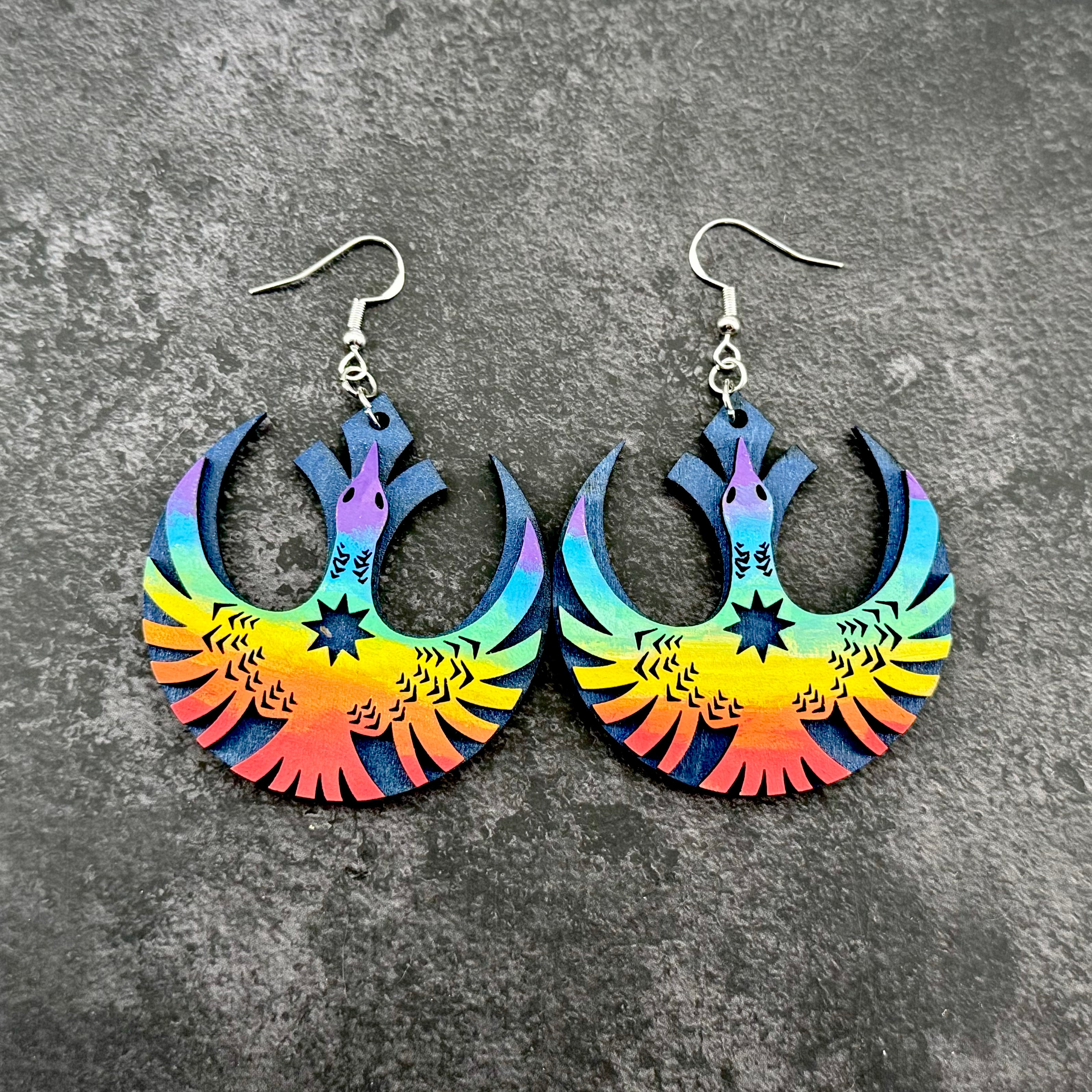 Rainbow rebel loon wooden earrings on gray stone background