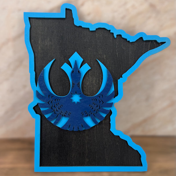 Blue emblem inside a black outline of a state on a wooden background