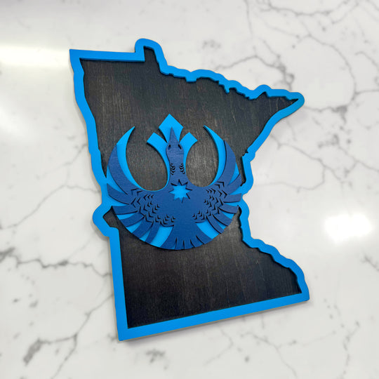 Minnesota-shaped wooden sign with blue cut-out design on a marble surface