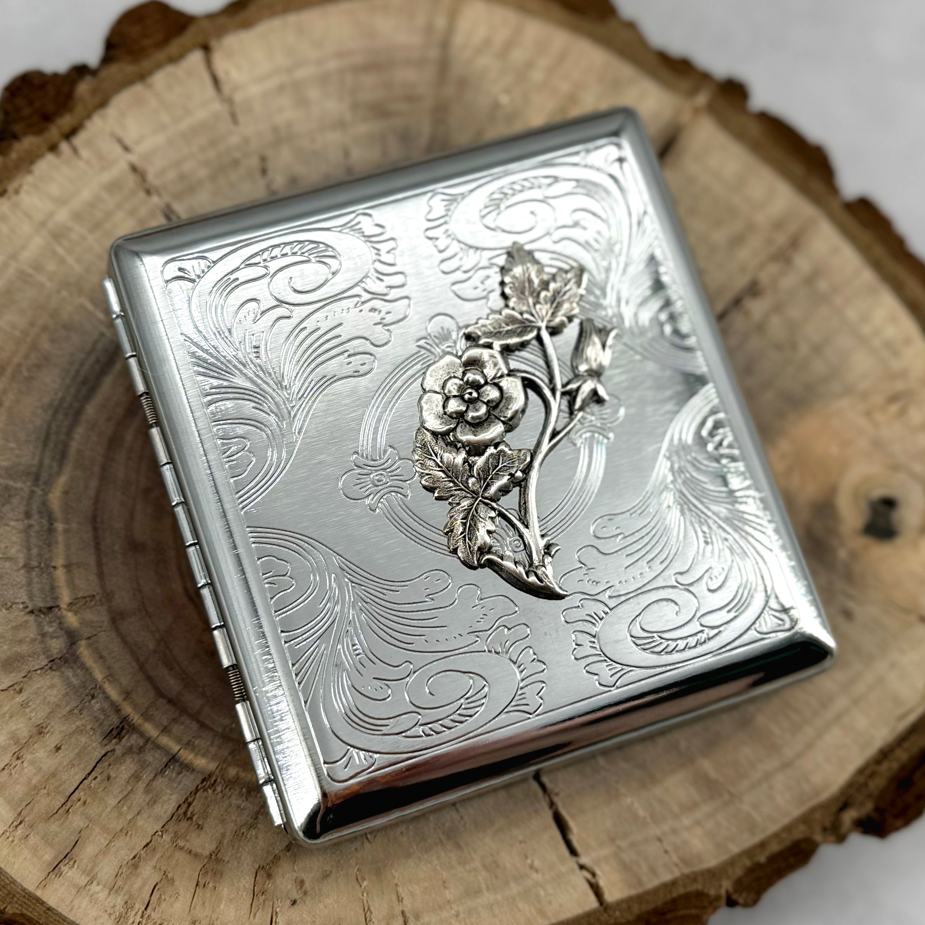 Compact metal pocket case with vintage-inspired flower design