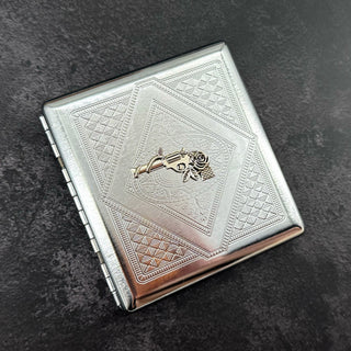 Handmade stamped metal western case featuring revolver and floral centerpiece