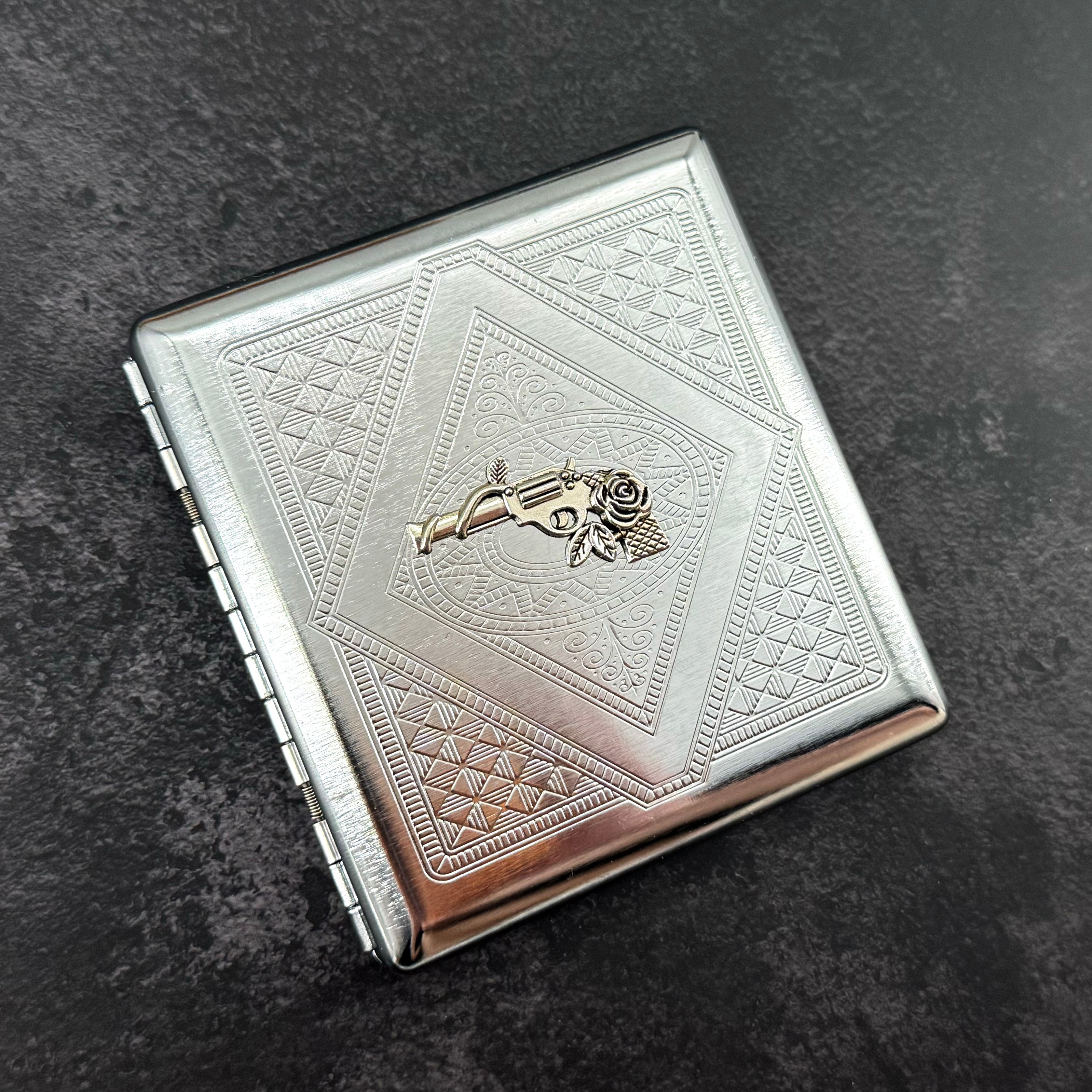 Handmade stamped metal western case featuring revolver and floral centerpiece