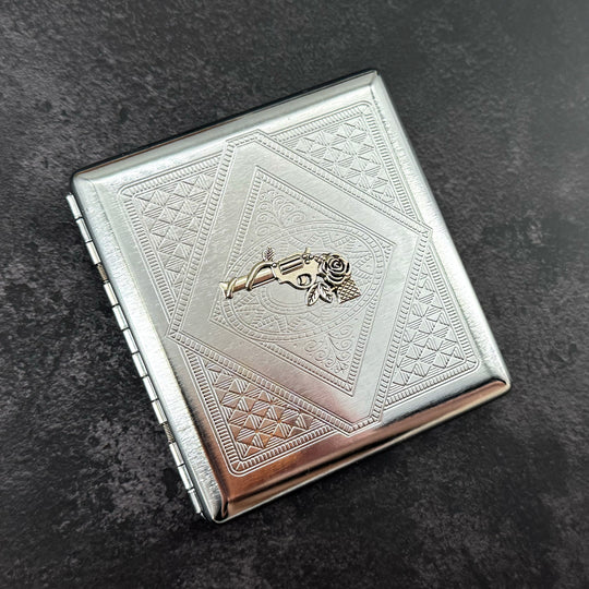 Handmade stamped metal western case featuring revolver and floral centerpiece