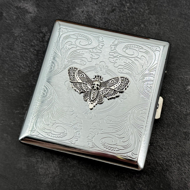 Silver Death's-head hawkmoth metal cigarette case with ornate stamped scrollwork background