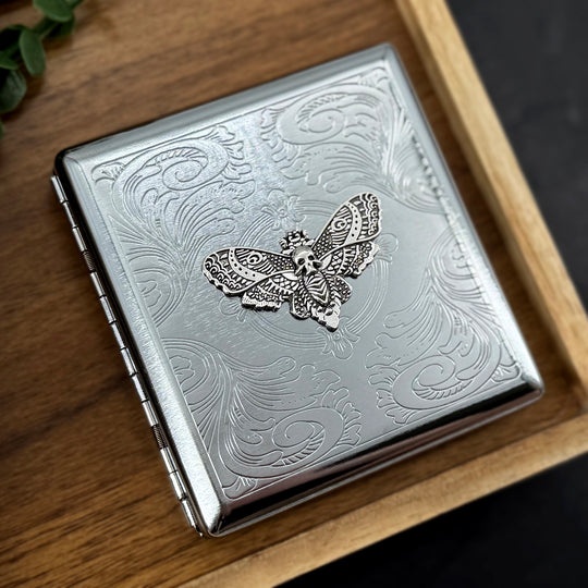 Close-up of the silver Death's-head hawkmoth embellishment on a handcrafted metal case