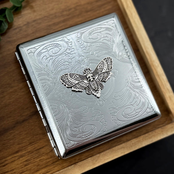 Close-up of the silver Death's-head hawkmoth embellishment on a handcrafted metal case