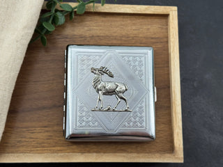 Close-up of raised deer detail on a silver geometric stamped cigarette case
