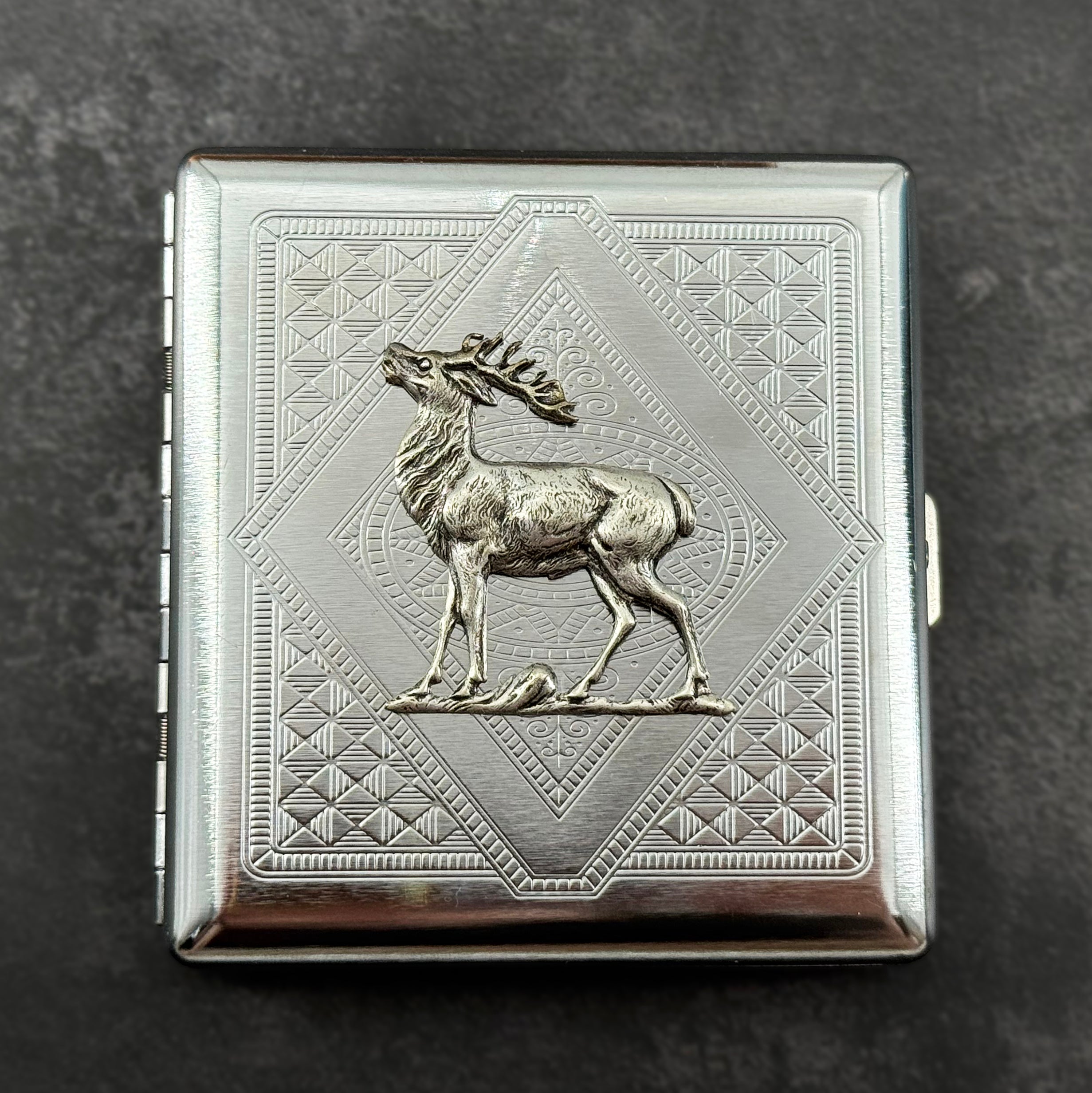 Woodland stag cigarette case with raised silver deer and geometric stamped background