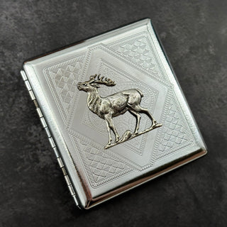 Silver metal cigarette case with woodland deer centerpiece and angular stamped design