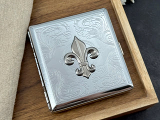 Silver fleur-de-lis cigarette case with stamped scrollwork background