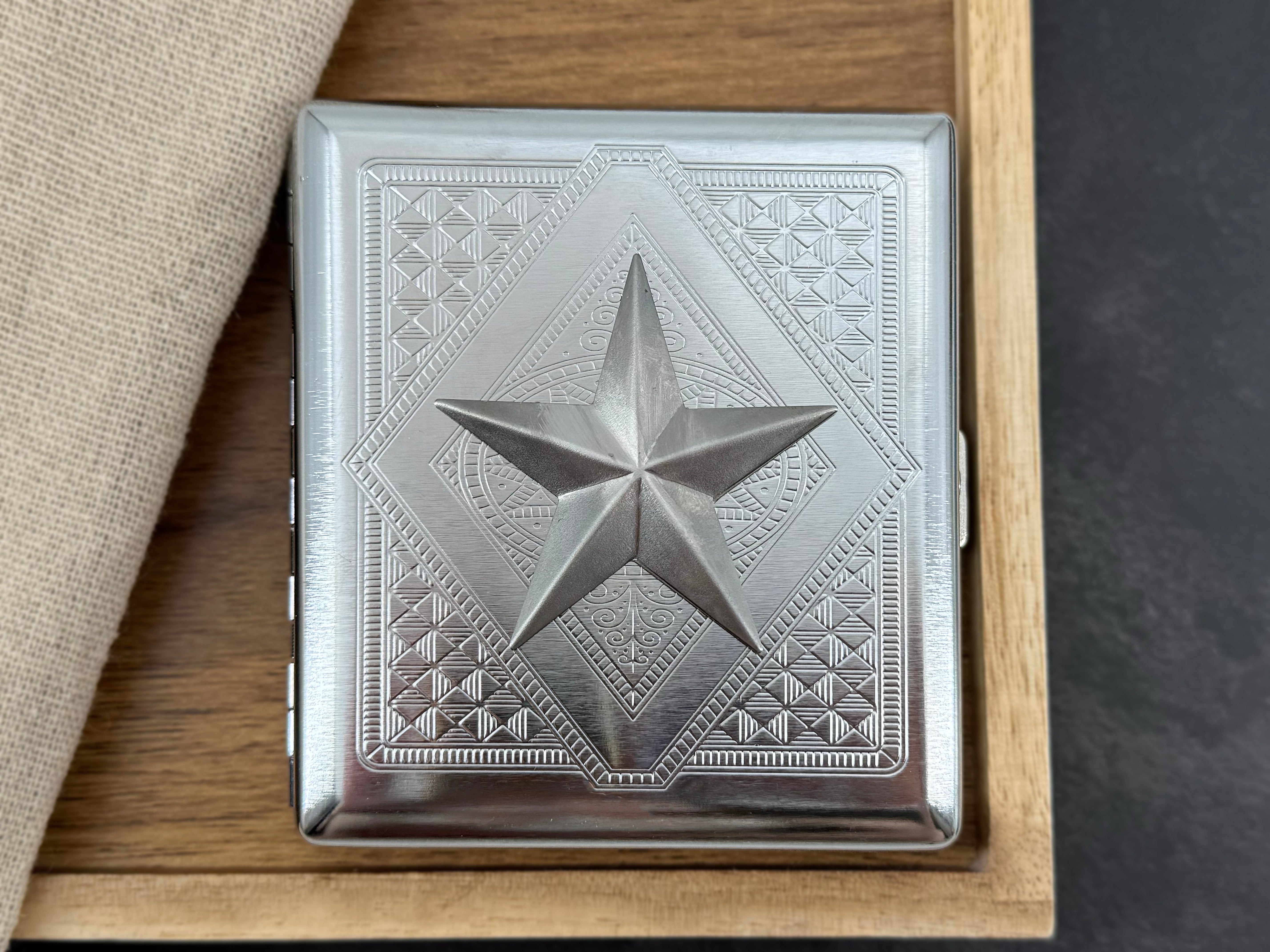 Silver nautical star cigarette case with faceted raised centerpiece