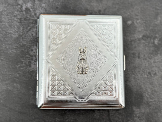 Handmade silver cigarette case featuring a small rabbit centerpiece and geometric metal pattern