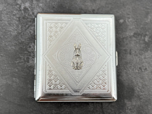 Handmade silver cigarette case featuring a small rabbit centerpiece and geometric metal pattern