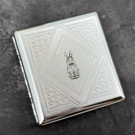 Silver rabbit card holder with textured stamped metal background and decorative geometric design