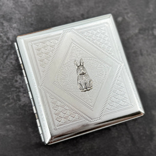 Silver rabbit card holder with textured stamped metal background and decorative geometric design