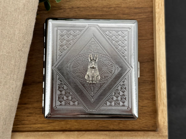 Rabbit cigarette case displayed on a wooden tray with silver-toned woodland design
