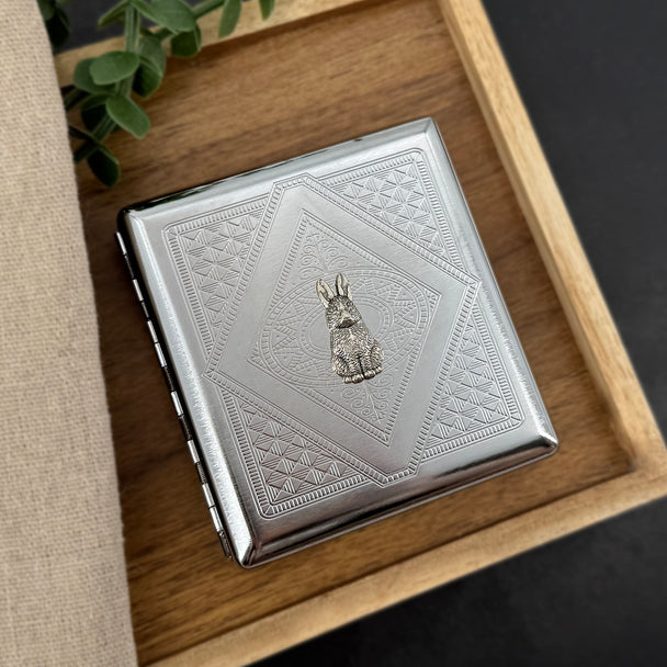 Silver bunny cigarette case with detailed geometric stamping and raised rabbit centerpiece