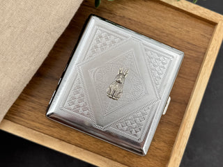 Detailed silver rabbit centerpiece on handmade metal cigarette and card case