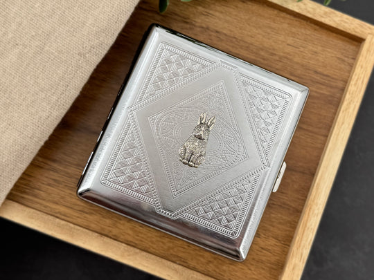 Detailed silver rabbit centerpiece on handmade metal cigarette and card case