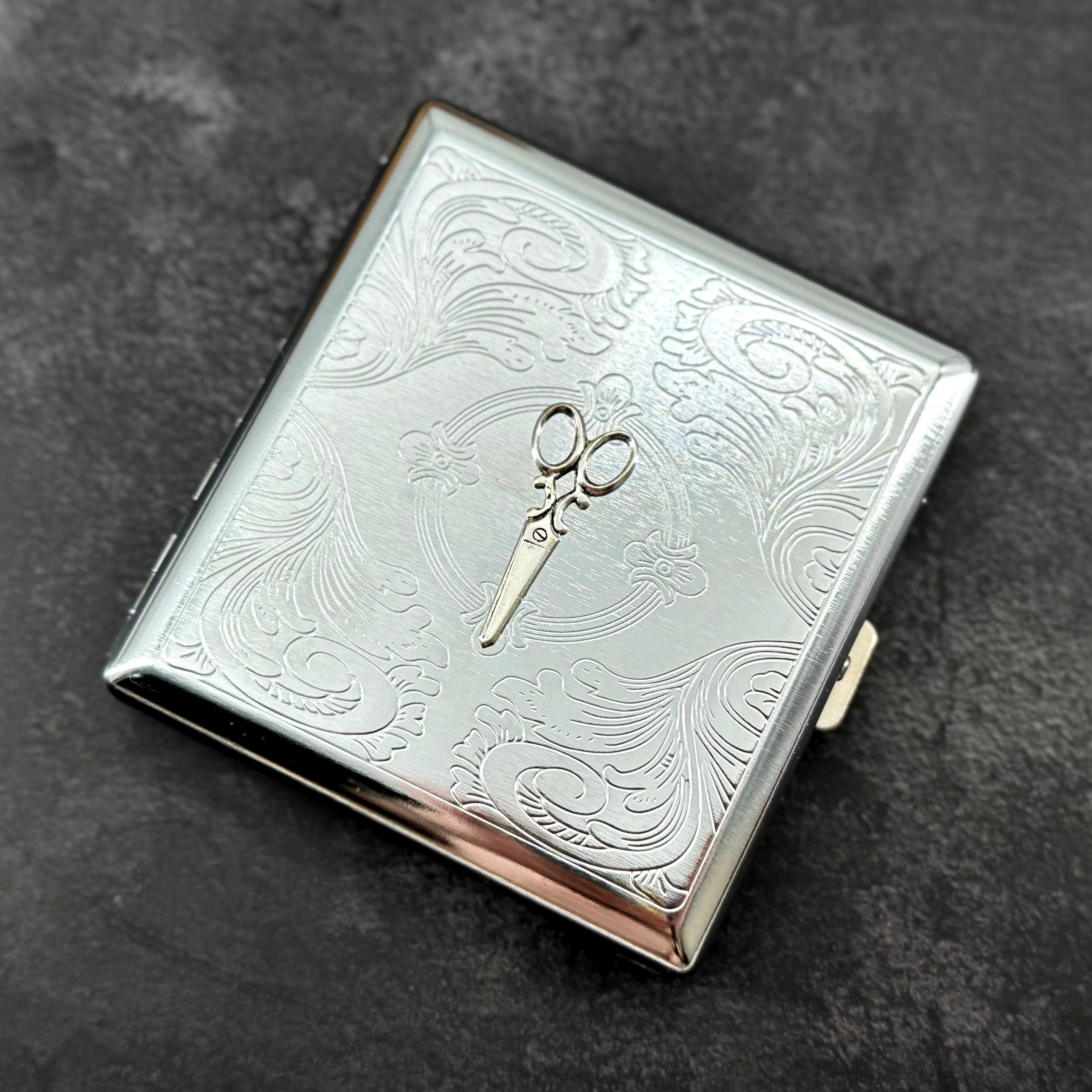 Ornate scissors business card holder with detailed stamped metal background and compact design