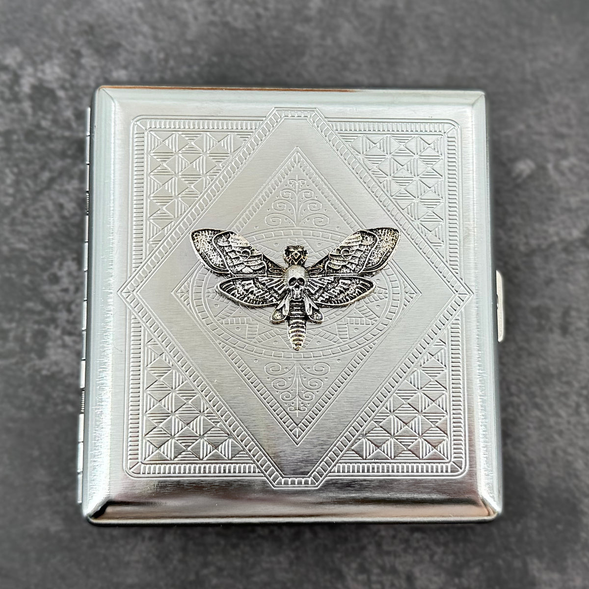 Silver skull hawkmoth metal cigarette case with detailed stamped background