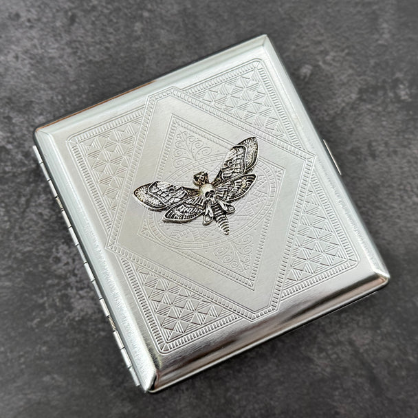 Gothic silver cigarette case featuring a spread-wing skull moth centerpiece