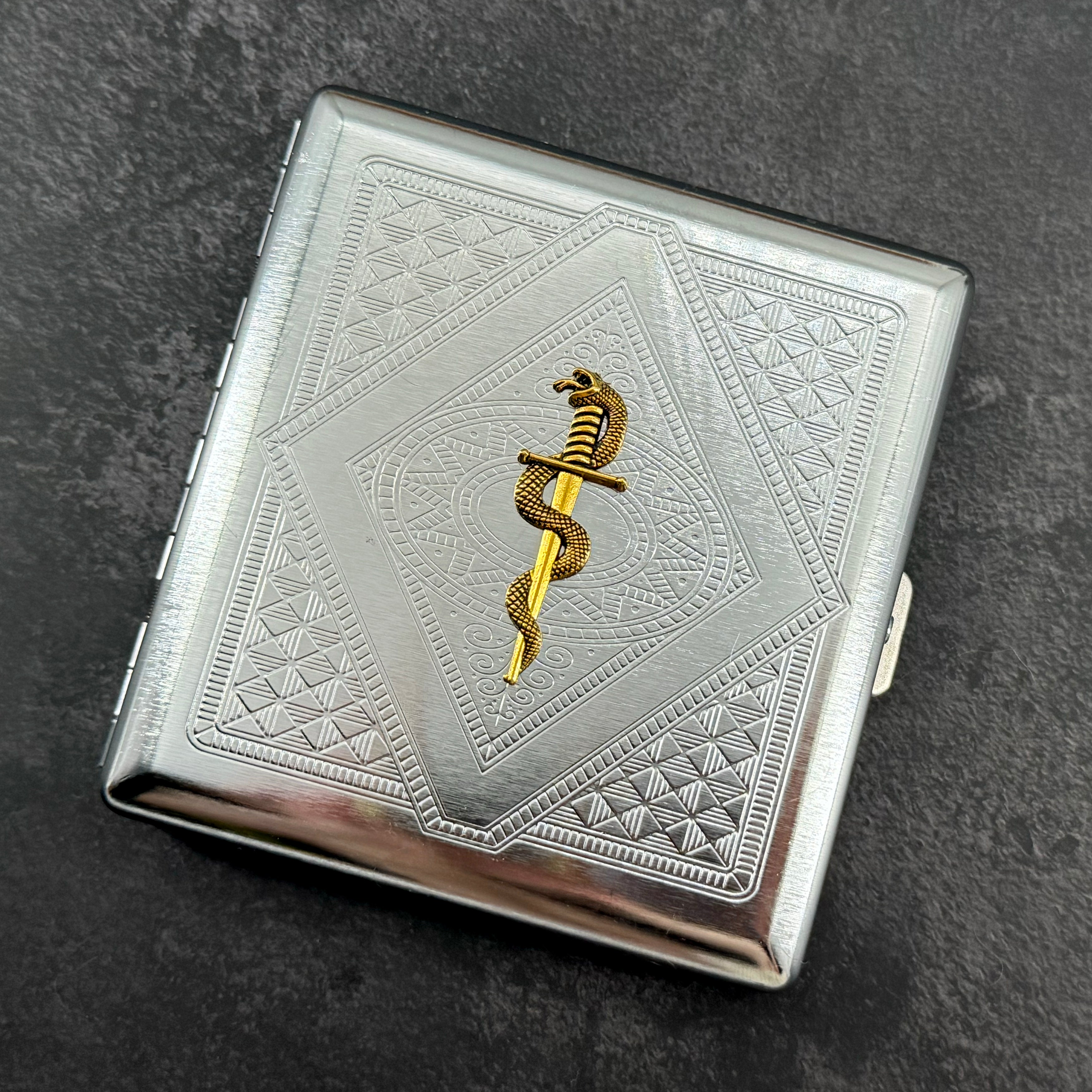 Handmade stamped metal snake case featuring geometric pattern and serpent wrapped around dagger