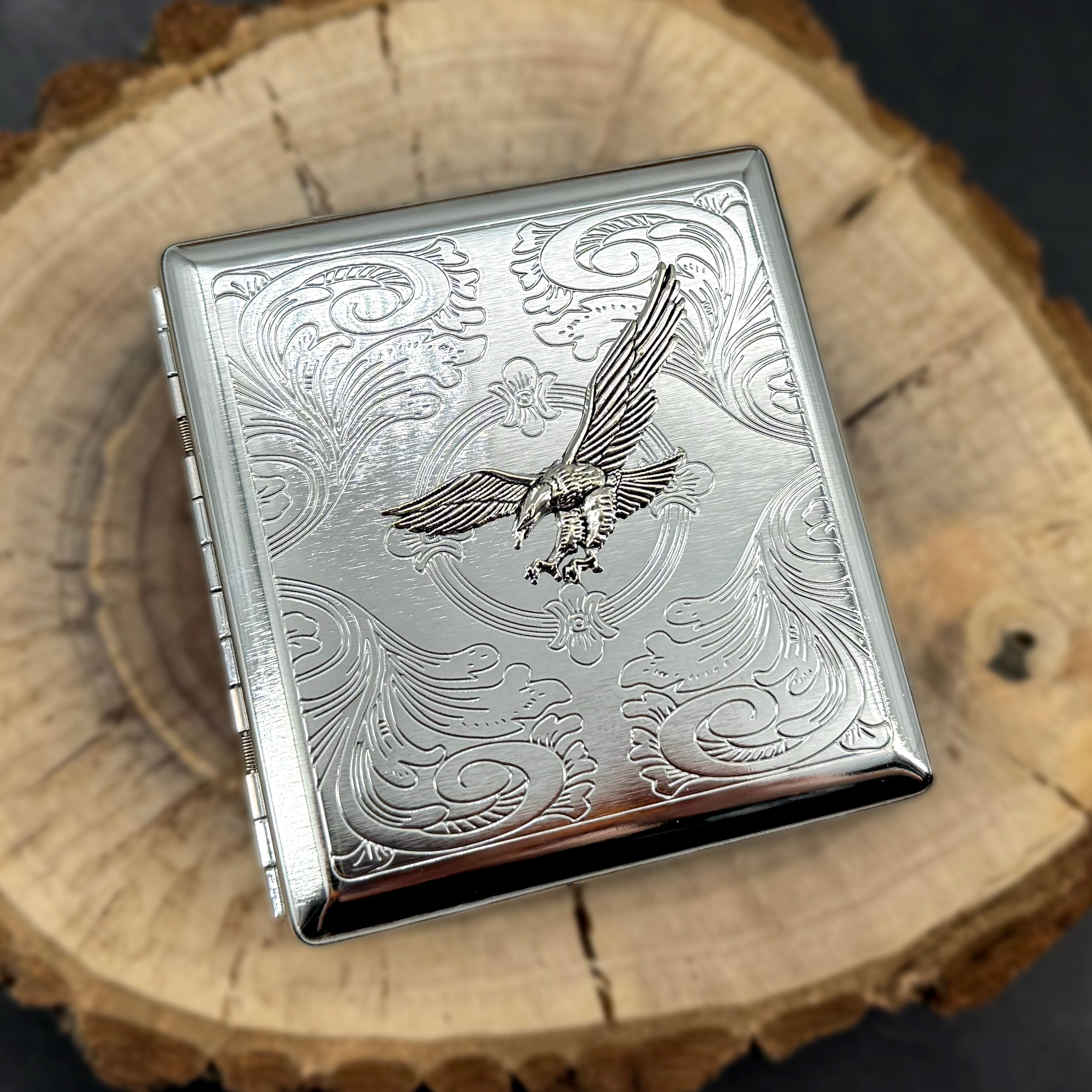 Handmade eagle cigarette case displayed on natural wood surface