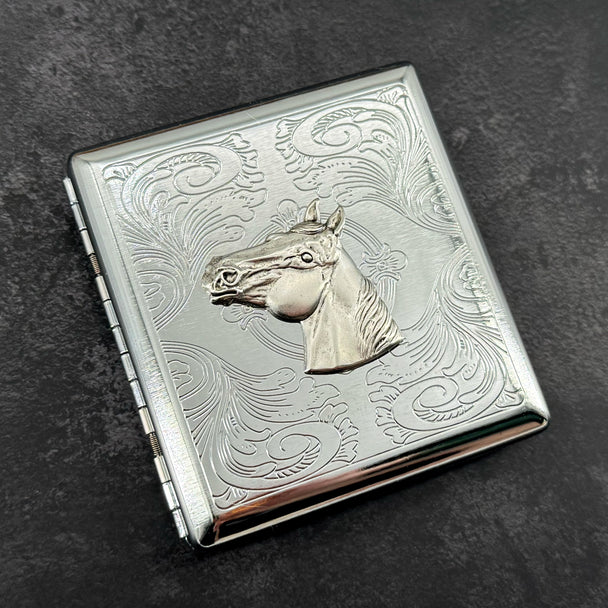 Silver stamped metal cigarette case with raised horse head and ornate scrollwork