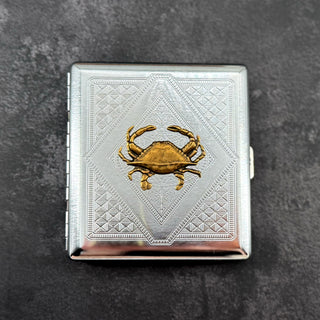 Crab cigarette case with raised bronze crab on silver stamped metal background