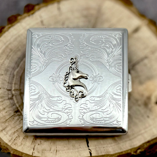 Handmade unicorn cigarette case displayed on natural wood slice