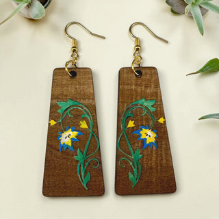 Wooden earrings with floral designs on a light background
