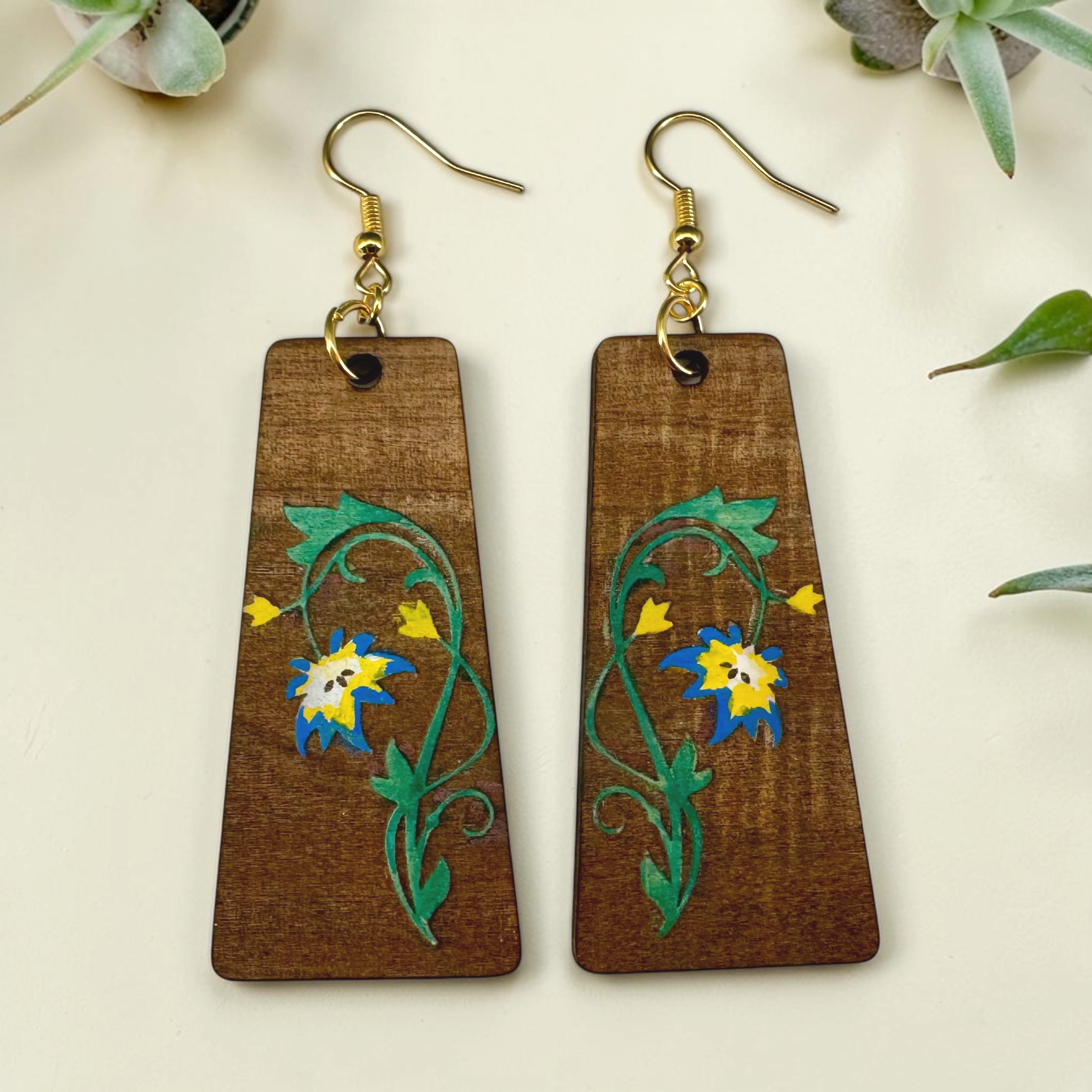 Wooden earrings with floral designs on a light background
