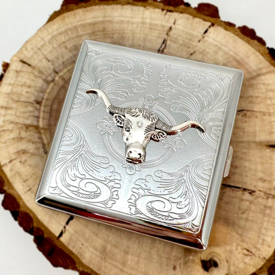 Western longhorn cigarette case with raised cattle emblem and engraved ornamental background
