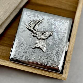 Deer head cigarette case with engraved scrollwork background