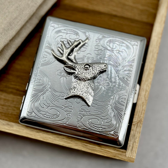 Deer head cigarette case with engraved scrollwork background