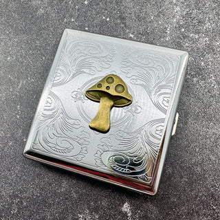 Mushroom cigarette case with raised toadstool design and engraved scrollwork