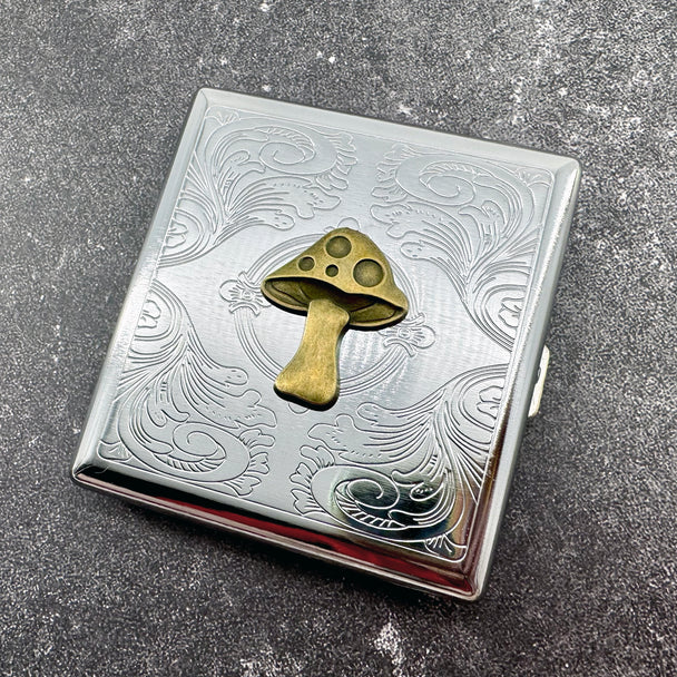 Mushroom cigarette case with raised toadstool design and engraved scrollwork