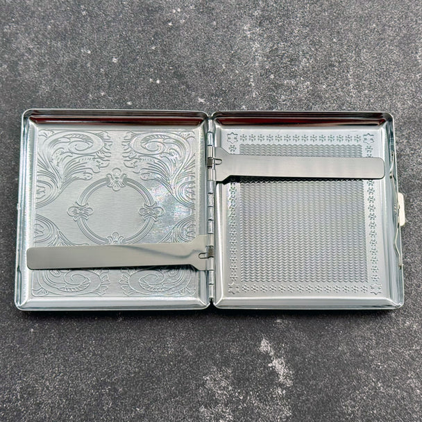 Open golden Death's-head hawkmoth metal cigarette case showing polished interior and spring-loaded cigarette clips